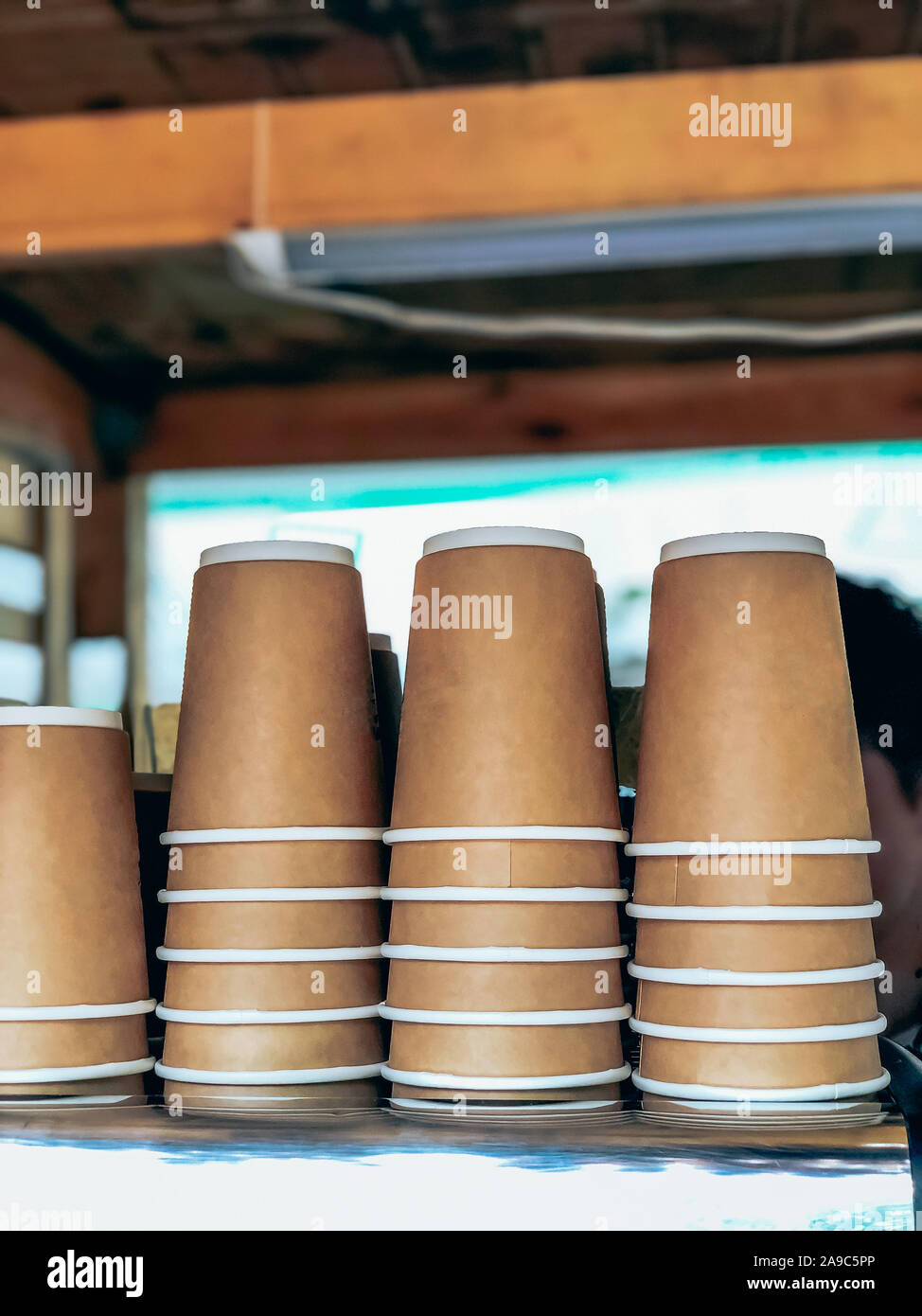 Disposable coffee cups piles in outdoor street market cafe. Street food and drinks take away