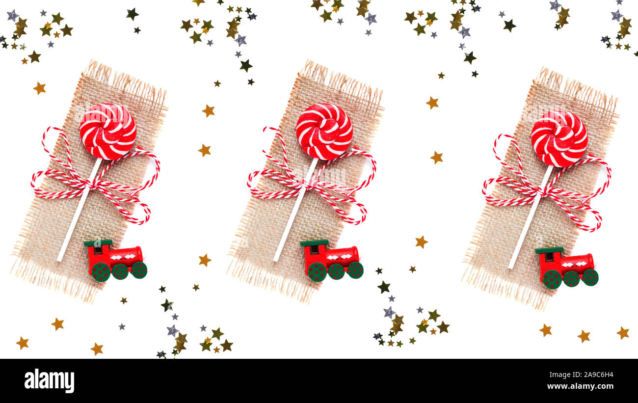 Christmas lollipop, toy train and ?hristmas tree branch on white. Copy