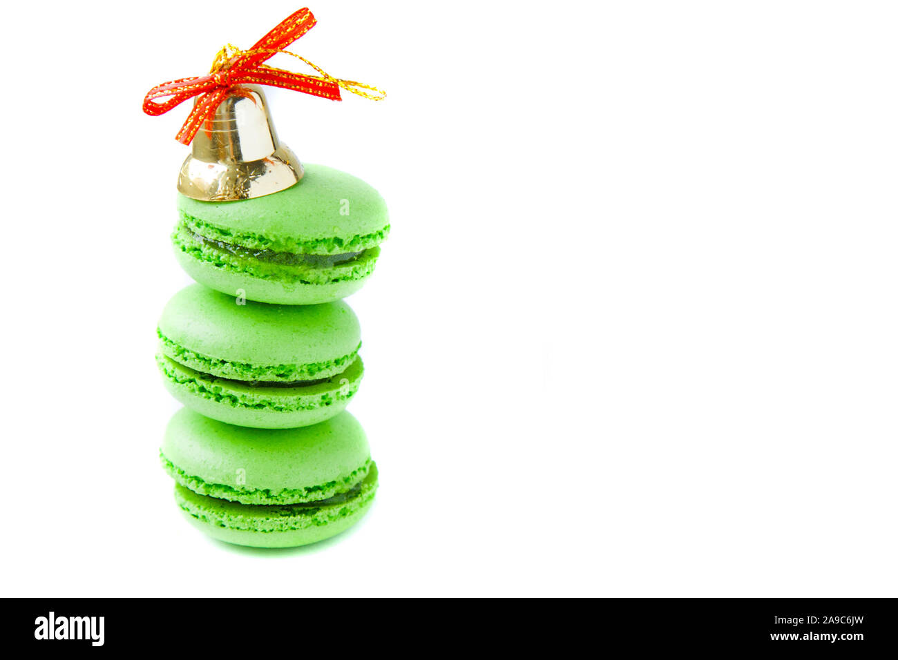 Green macarones with golden christmas bell and on white background Stock Photo