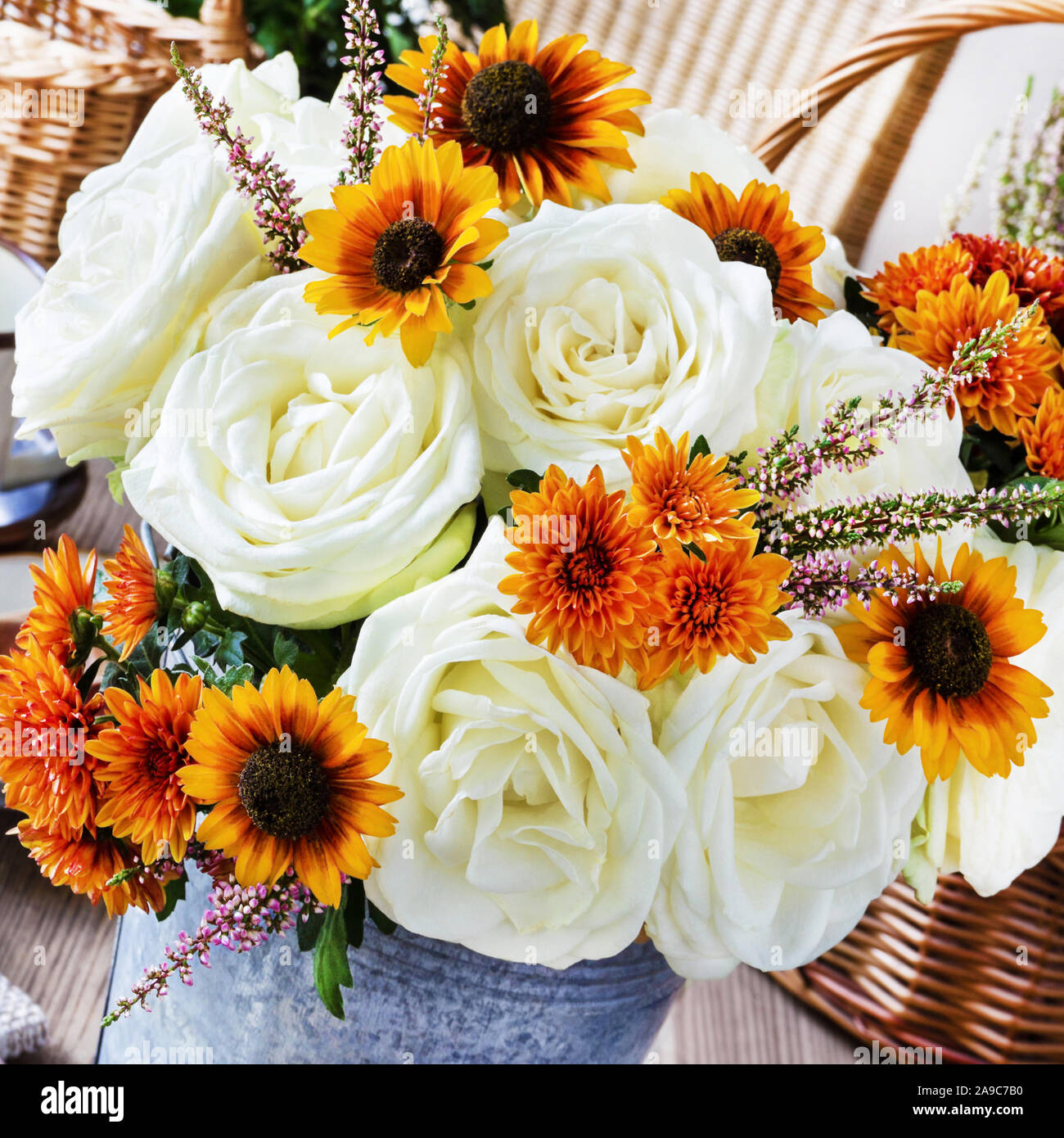 Autmn decorations and white roses bouquet in basket Stock Photo