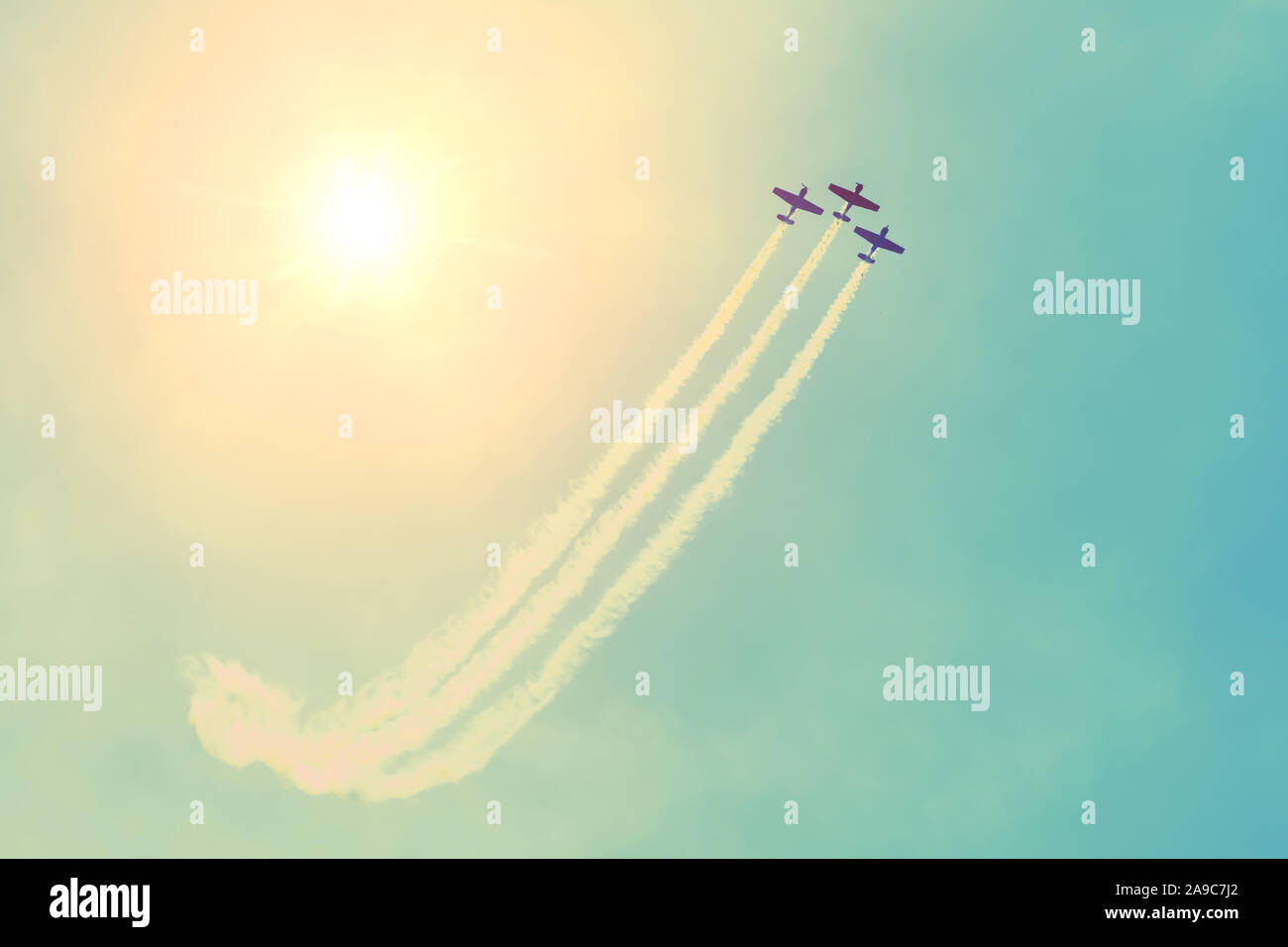 Group of three turboprop aircraft flying in the sky sun shine leaving a ...