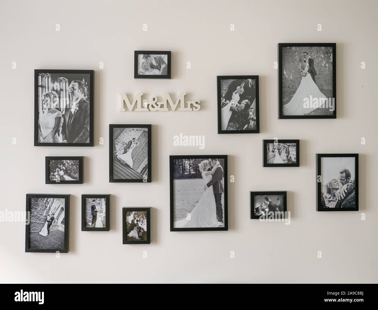 Black and white wedding photos hanging on bedroom wall at home Stock Photo