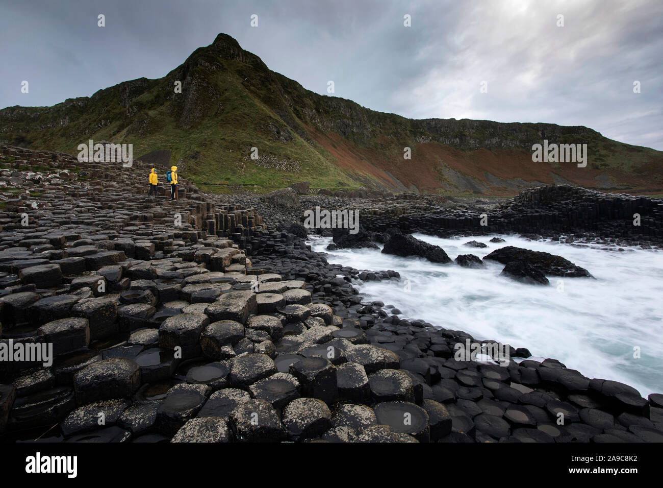Mother and son standing on pile of rock columns formation at Giant's Causeway, Co. Antrim, Northern Ireland Stock Photo