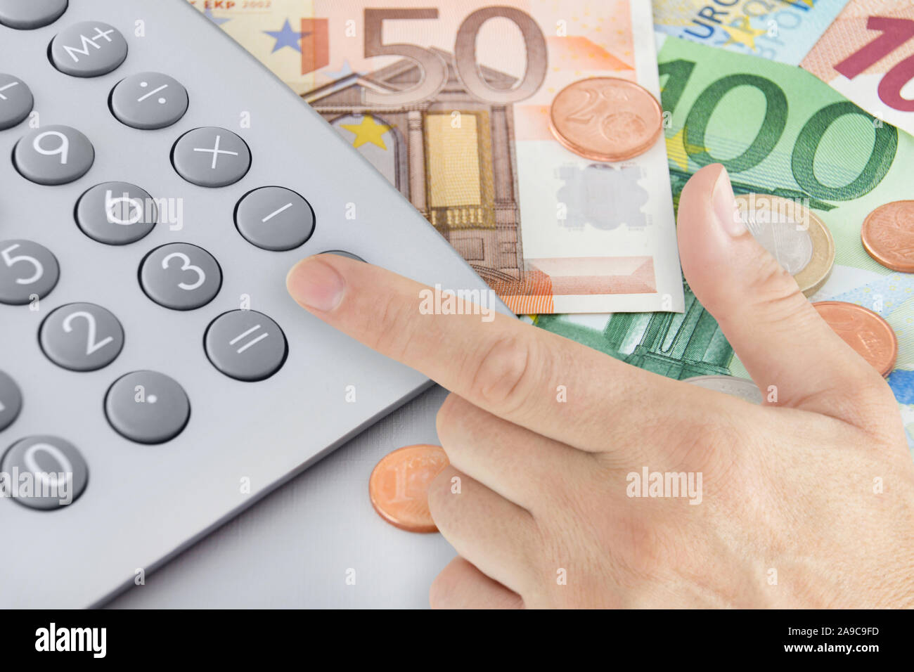 Euro with calculator and male hand Stock Photo