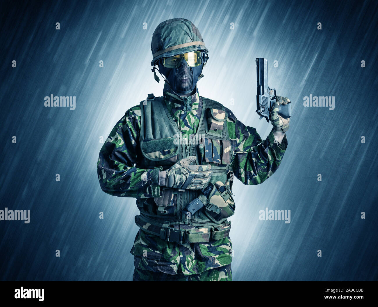 Armed soldier standing in rainy weather Stock Photo