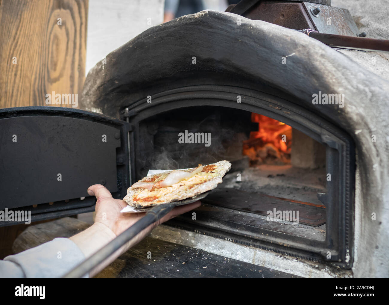 Chef taking out pizza from an oven. Stock Photo