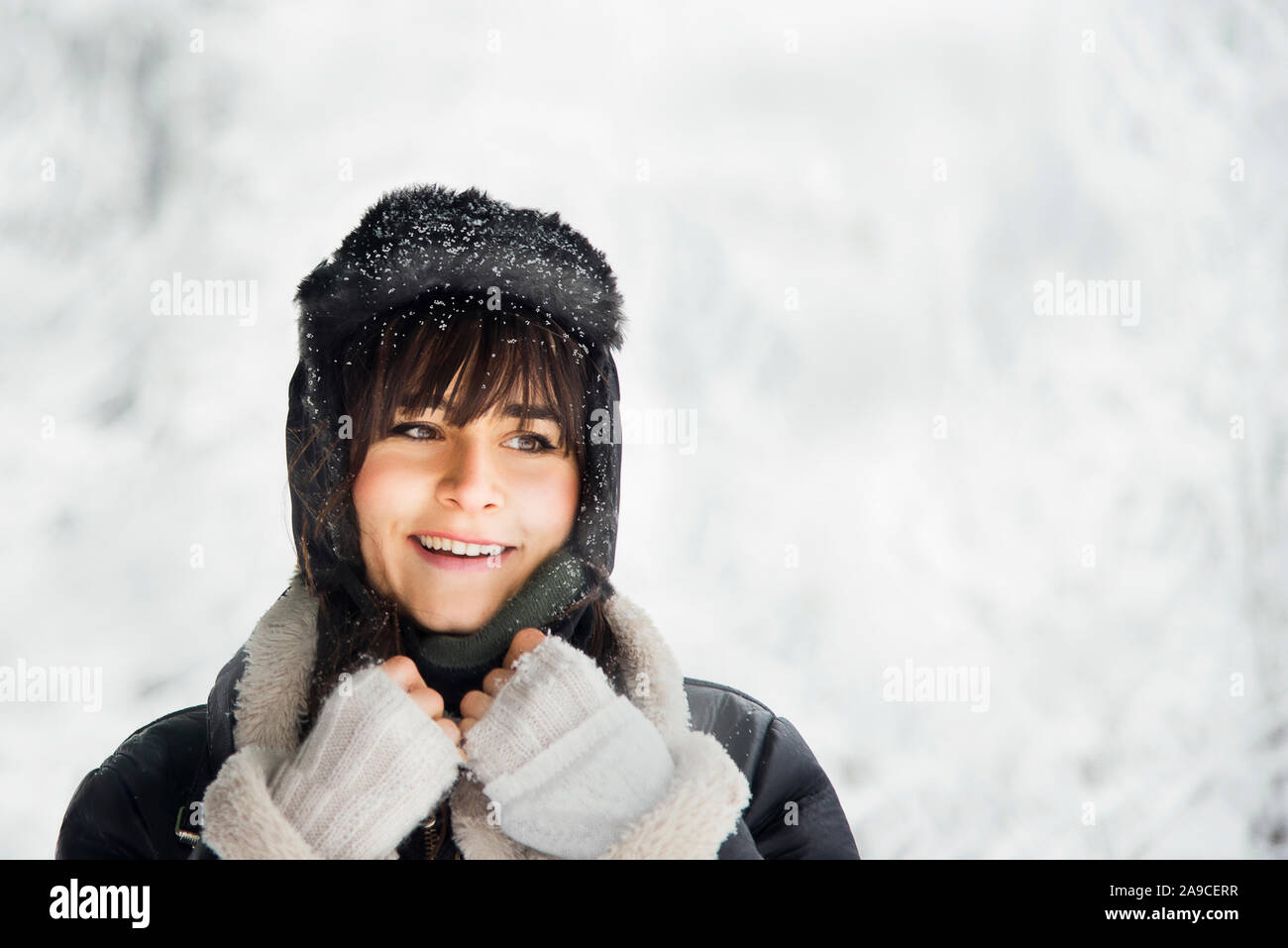 Portrait of a caucasian white woman under blizzard with hat, coat and bangs. Stock Photo