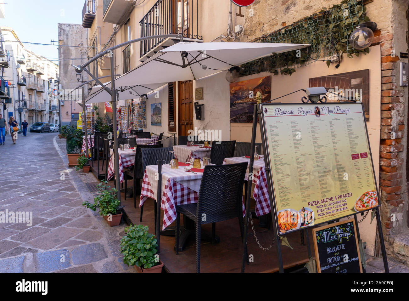 Outdoor dining in Cefalú. tables laid out in time for the evening trade. Stock Photo