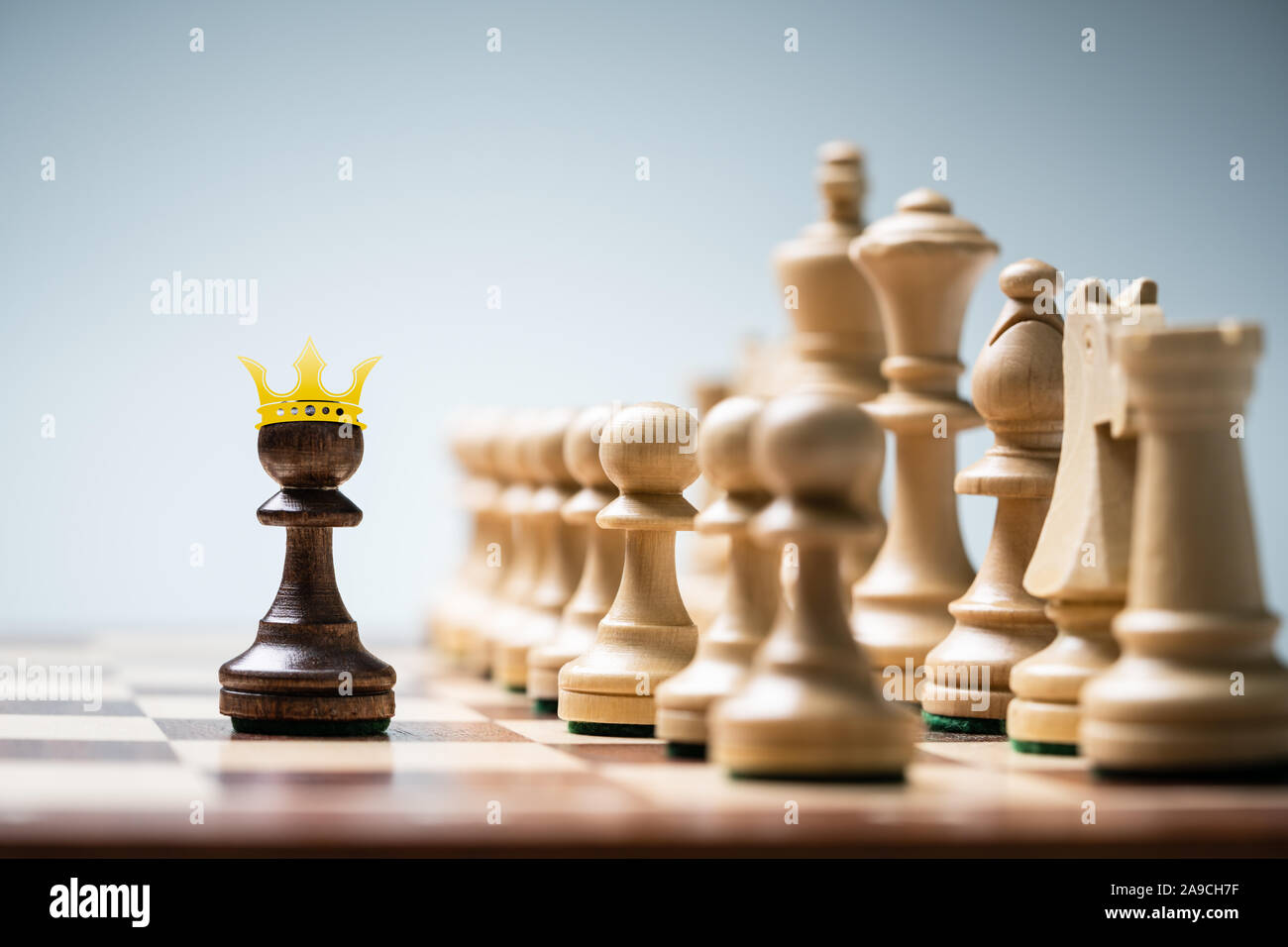 Row Of Chess Pieces On Board Against Blue Background Stock Photo
