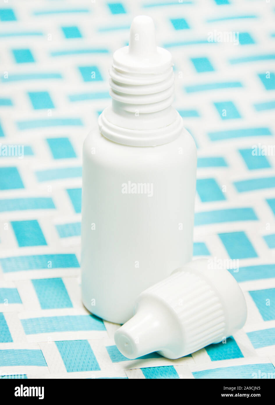 Medical eye drops and blue background Stock Photo - Alamy