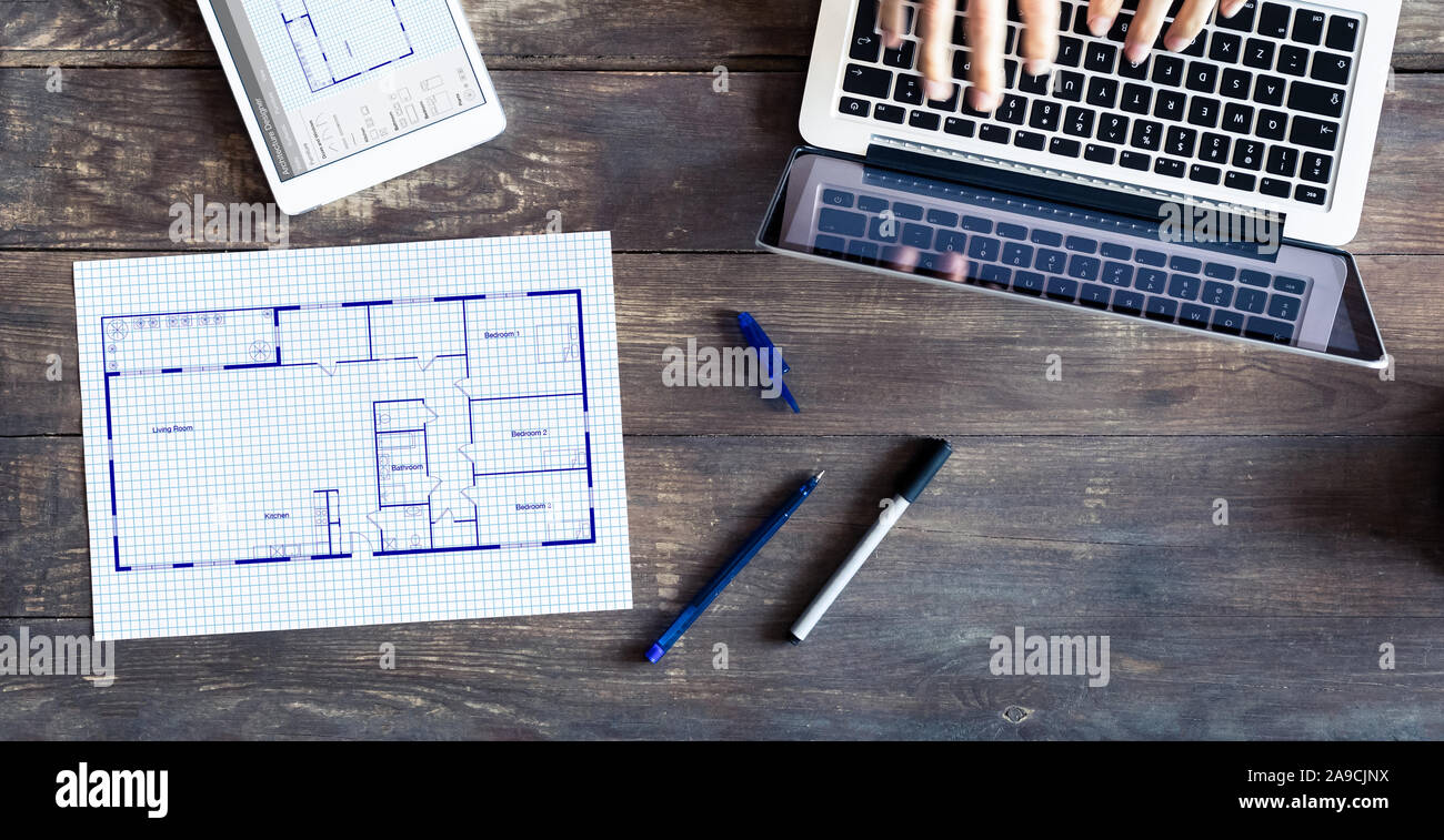 Floor plan drawing with architect designing home on computer, old wooden desk with blueprint of house or apartment project Stock Photo