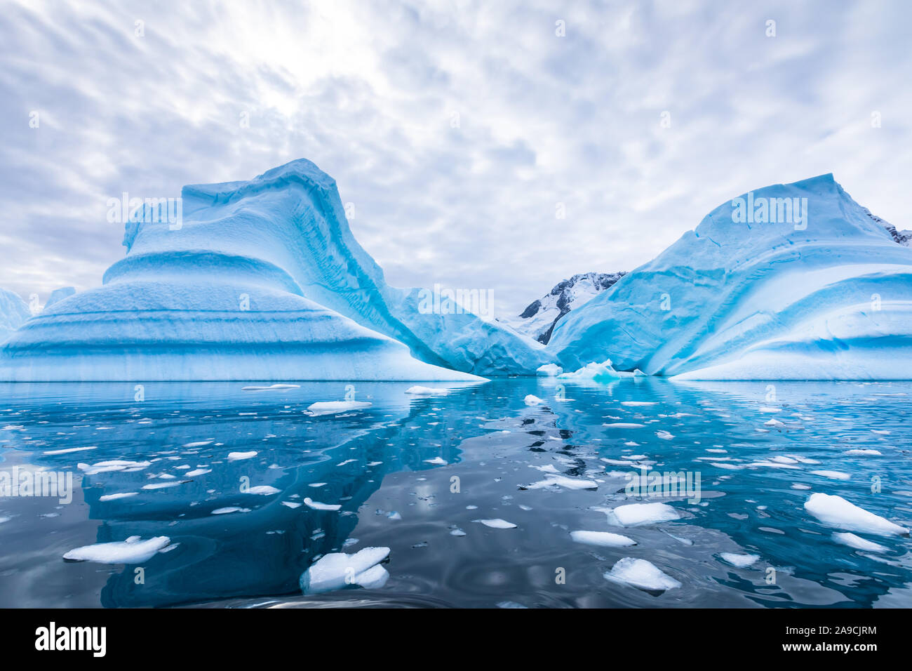 Iceberg in Antarctica floating in the sea, frozen landscape with massive pieces of ice reflecting on water surface, Antarctic Peninsula Stock Photo