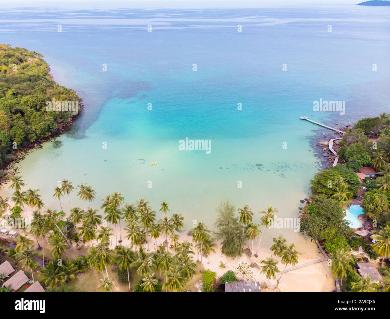 Tropical beach aerial view from drone with blue transparent sea water and coconut palm trees, seaside tourist hotel resort with beautiful landscape fo Stock Photo