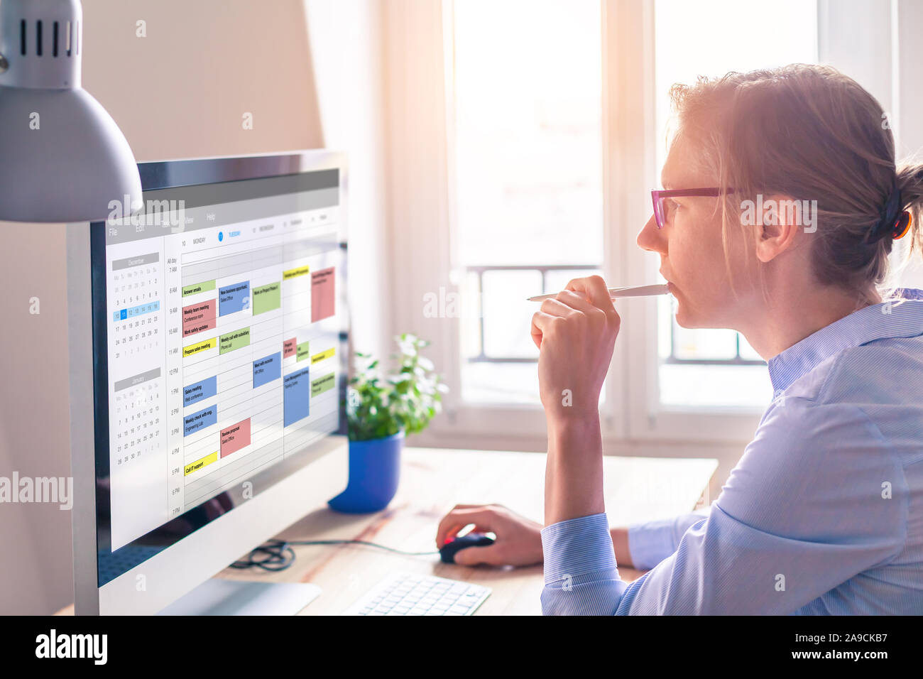 Person using calendar on computer to improve time management, plan appointments, events, tasks and meetings efficiently, improve productivity, organiz Stock Photo