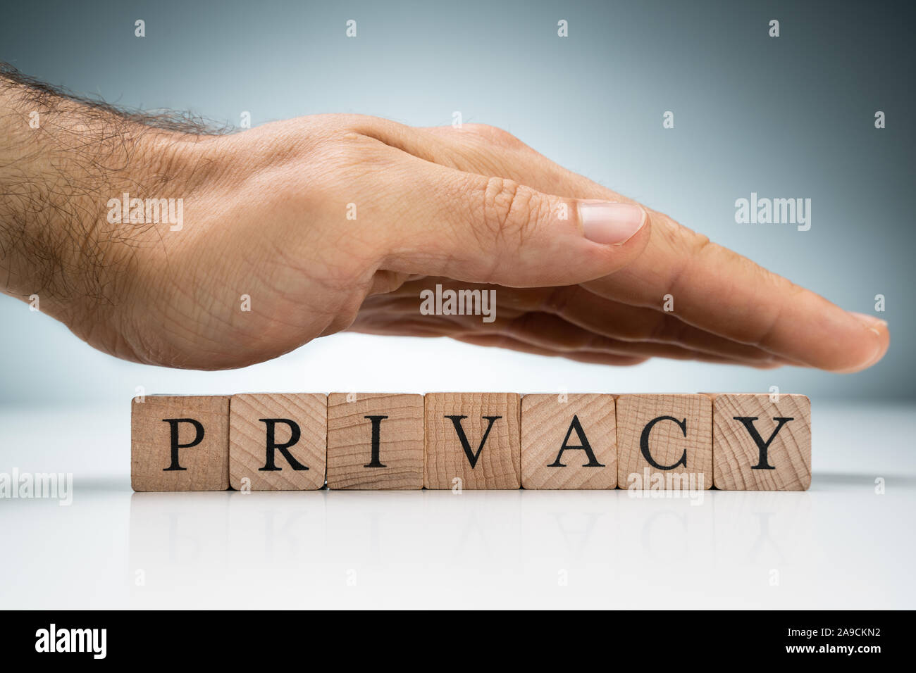 Hand Privacy Man's Hand Over The Privacy Wooden Blocks On White Desk Against Blue ...