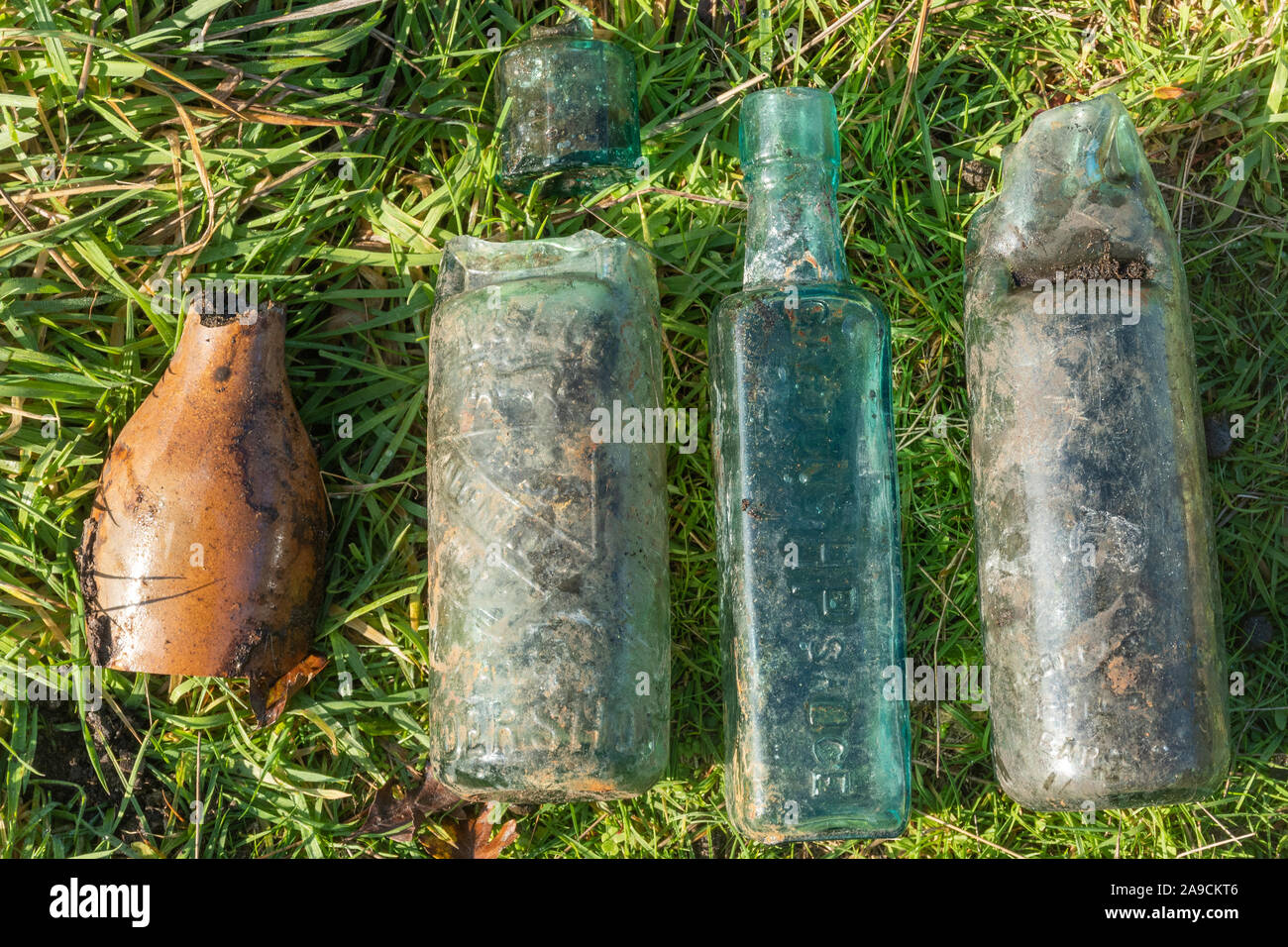 Vintage bottles arranged on the grass at an old bottle dump, UK Stock Photo