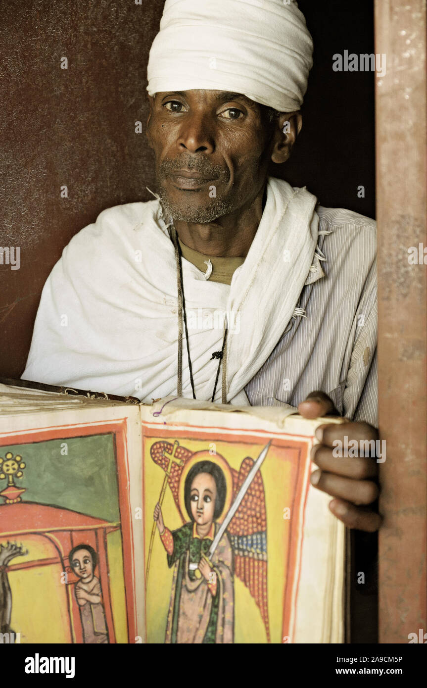 Priest with an illuminated holy book in Narga Selassie church, Lake Tana, Ethiopia Stock Photo