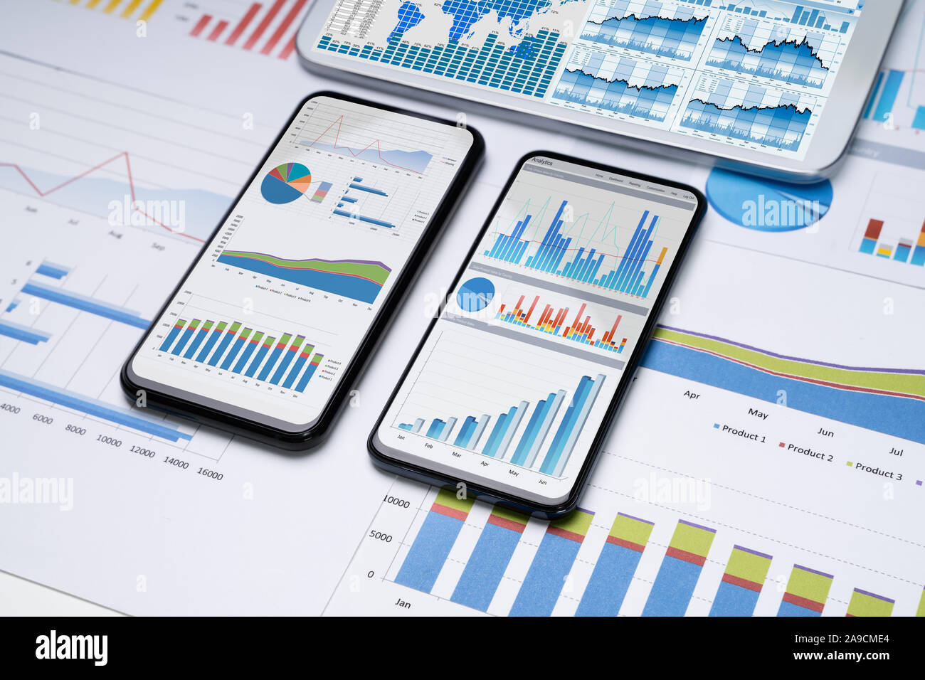 Close-up Of Financial Graphs On Screens Of Multiples Smartphones On Desk Stock Photo