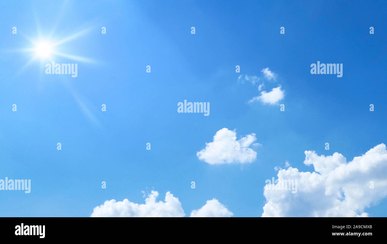 a bright blue sky with sun and clouds background Stock Photo