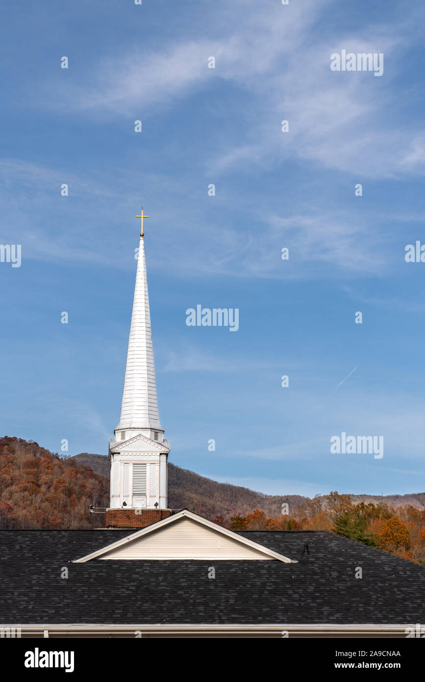 White steeple on a Baptist church with autumn colors, mountains and blue sky. Stock Photo