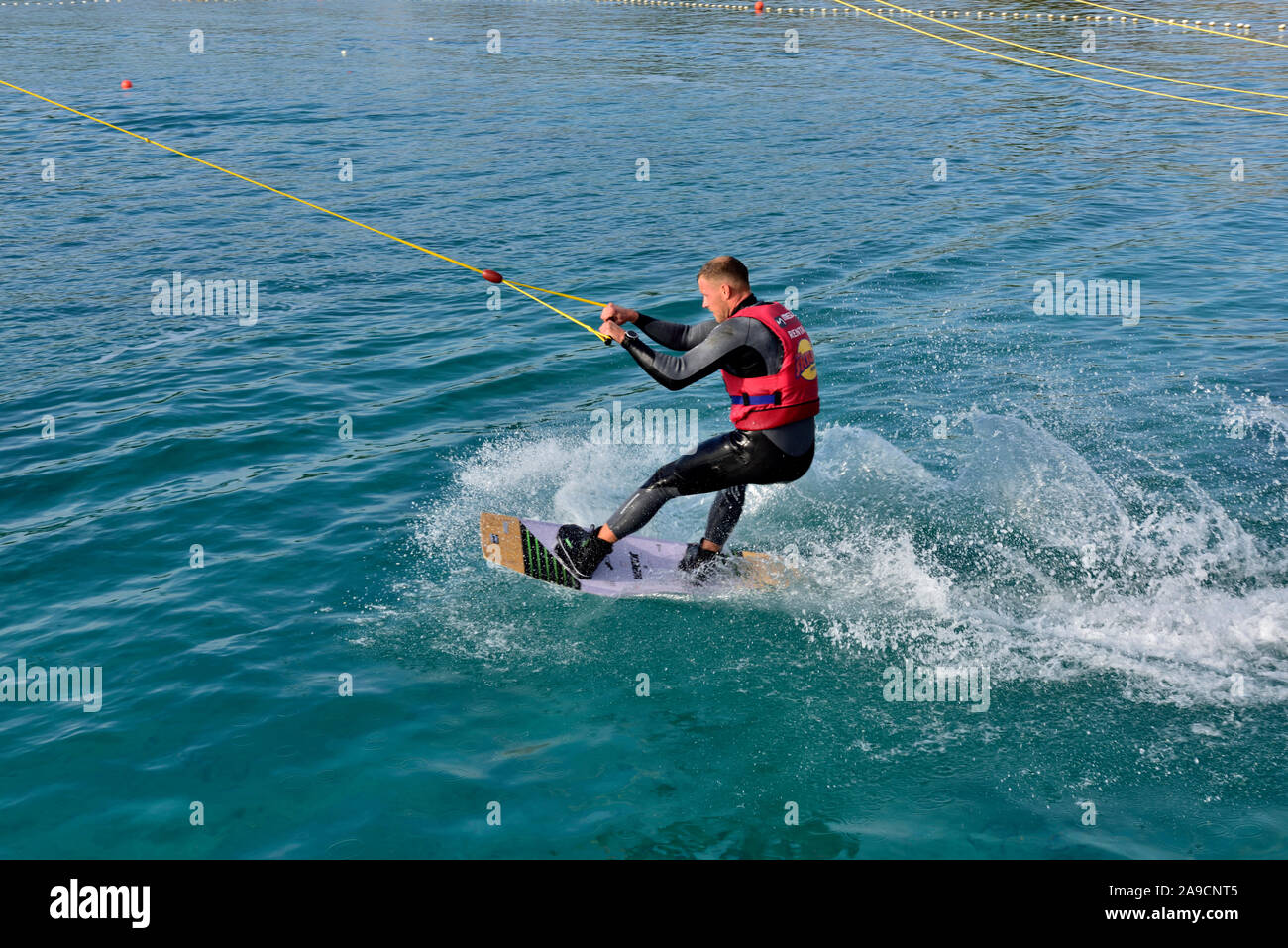 Cable wakeboarders just starting his tow on Uvala valovine bay by Wake