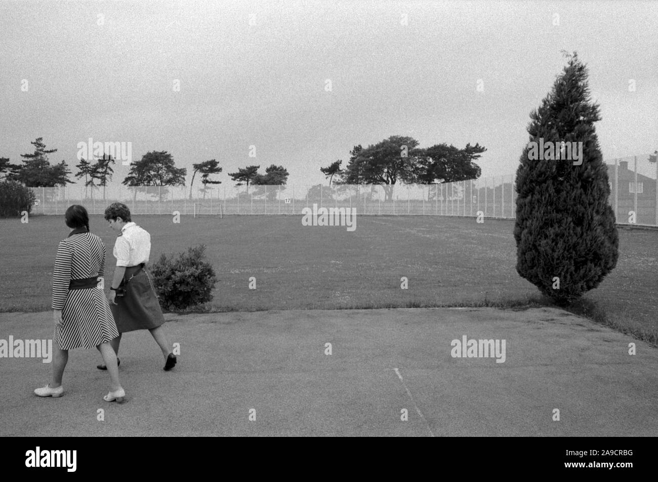 Womens jail 1980s UK. Prisoner and guard walk, exercising in grounds of HM Prison Styal Wilmslow Cheshire England 1986. HOMER SYKES Stock Photo