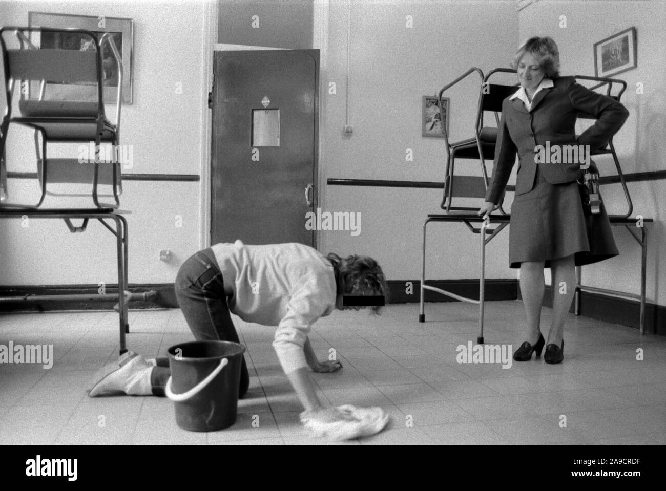 HM Prison Styal Wilmslow Cheshire UK 1980s. Female Inmate womens prison, prison guard the officer standing over female prisoner who is cleaning the floor.  Cheshire 1986 England HOMER SYKES Stock Photo