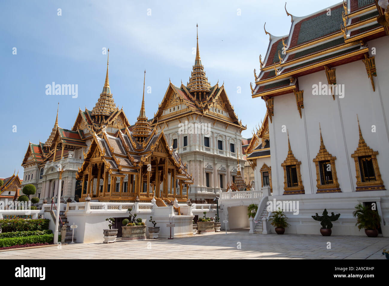 Wat Phra Kaeo, Bangkok, Thailand. Golden rooftops as far as the eye can see. Nicely cut bushes around the surrounding walls. Everything is clean and t Stock Photo