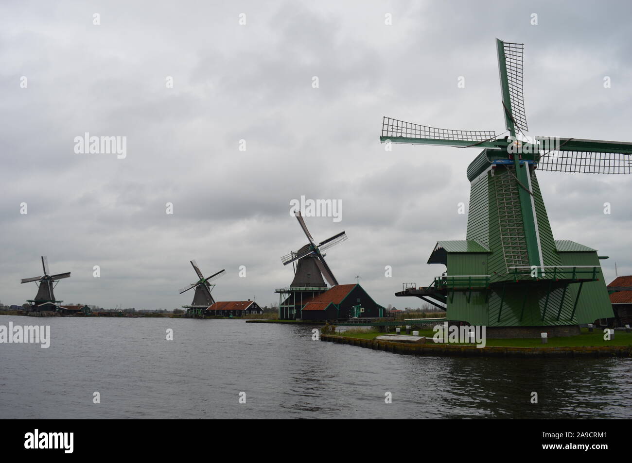 Zaandam, Netherlands. 11 November, 2019. Historic Dutch windmills in Zaanse Schans along the river of De Zaan. Stock Photo