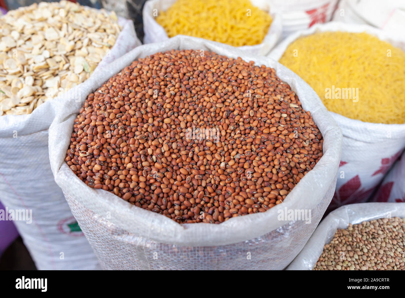 Different kind of ingredients as beans, corn, lentils all filled in bags in a grocery store in Morocco. Typical arrangement of everyday food. Stock Photo