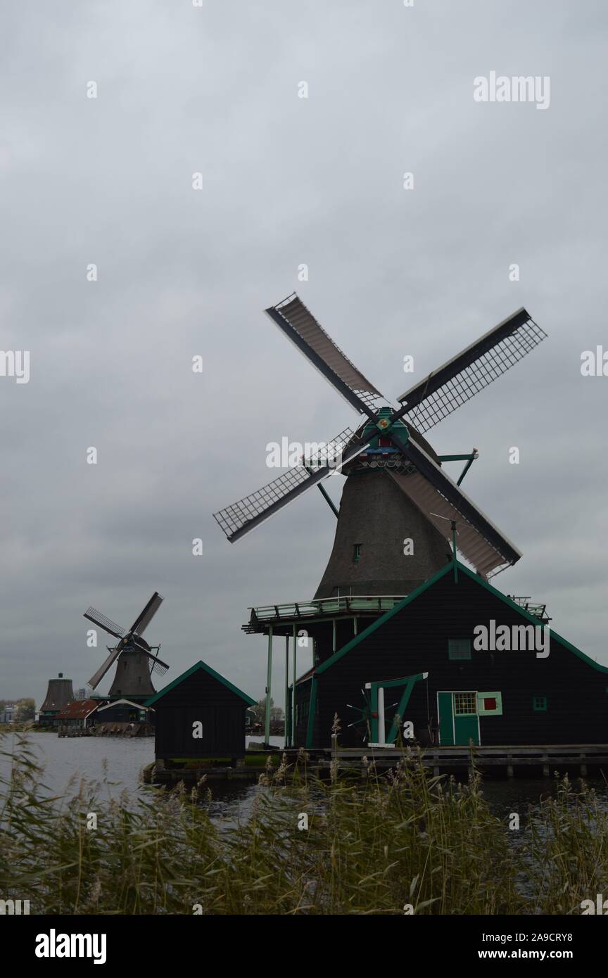 Zaandam, Netherlands. 11 November, 2019. Historic Dutch windmills in Zaanse Schans along the river of De Zaan. Stock Photo