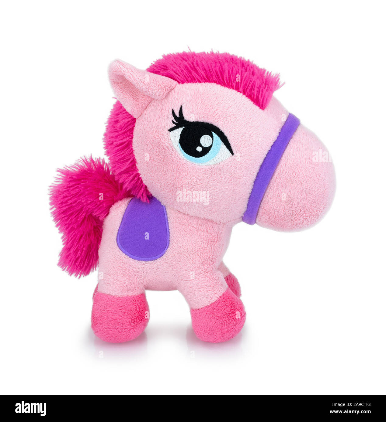 Cute pink horse plushie doll isolated on white background with shadow reflection. Playful bright pink pony on white underlay. Teddy horse plush. Stock Photo