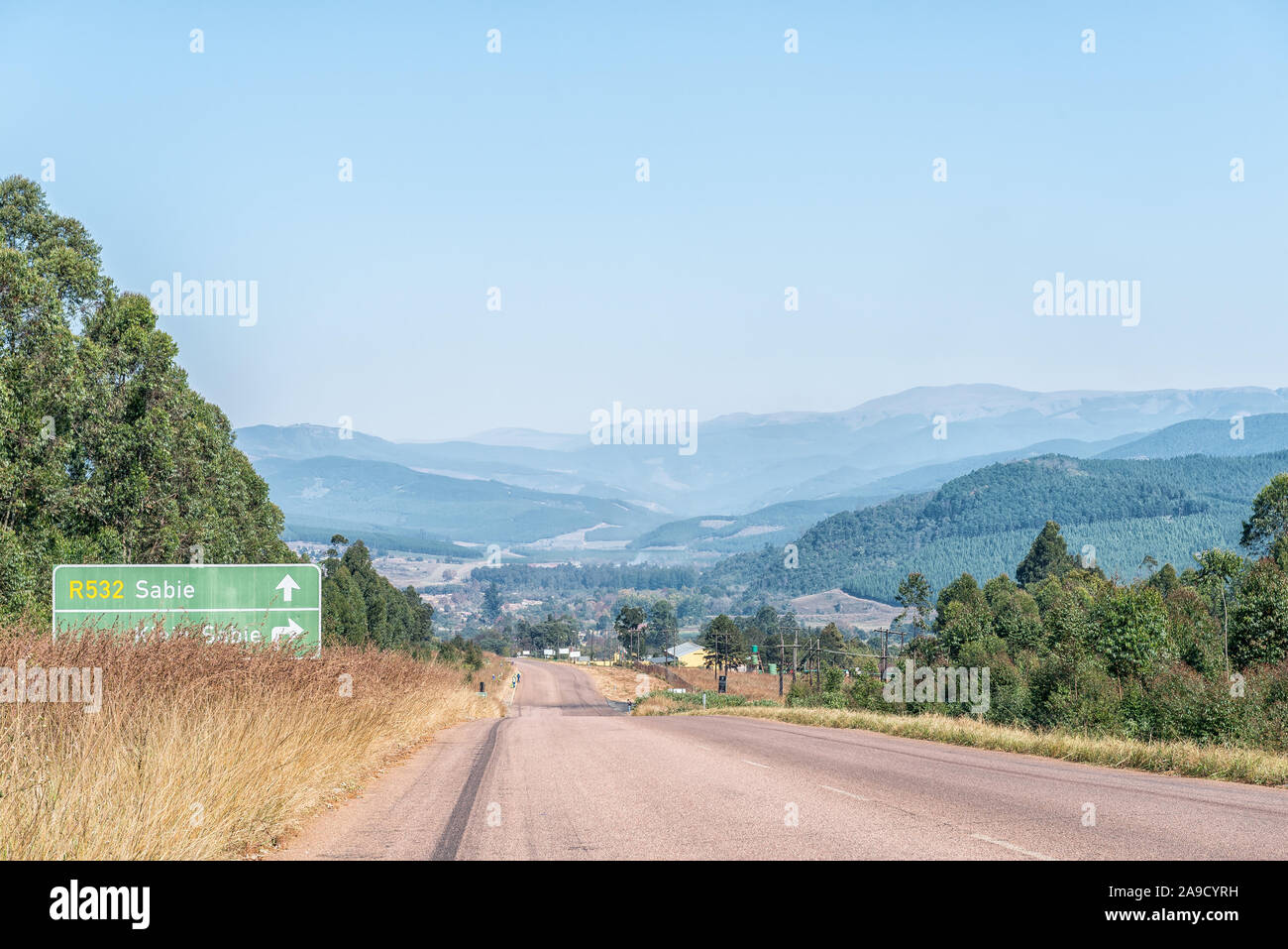 A view of the landscape on road R532 near Sabie. A directional sign is visible Stock Photo