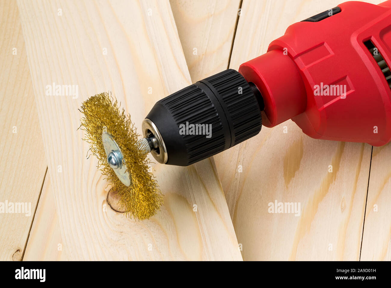 Red electric drill with round metal wire brush for cleaning of metal and  wood and remove rust over rough wooden surface. Construction and repair  Stock Photo - Alamy