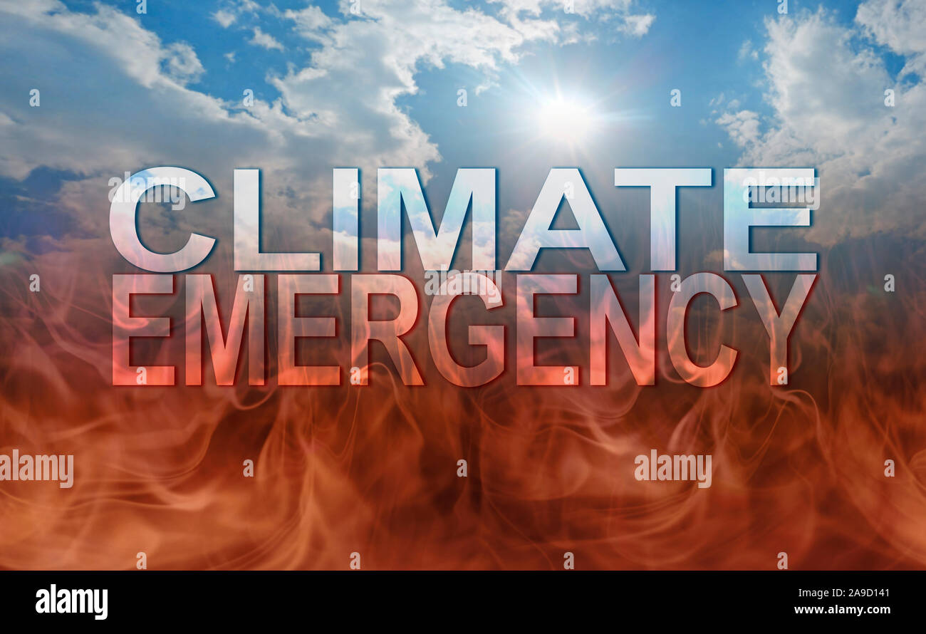 CLIMATE EMERGENCY concept - blue sun and sky background deteriorating into dark flames as earth burns with the transparent words CLIMATE EMERGENCY Stock Photo