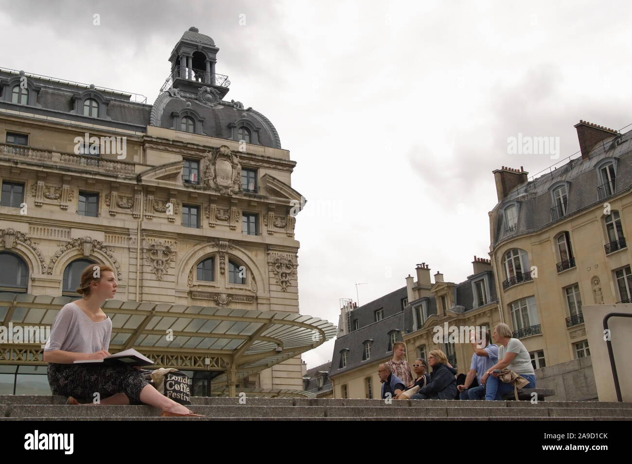 Paris, Ile de France / France - June 20, 2016: Tourist draws in her sketchbook outside of the Musee d'Orsay Stock Photo