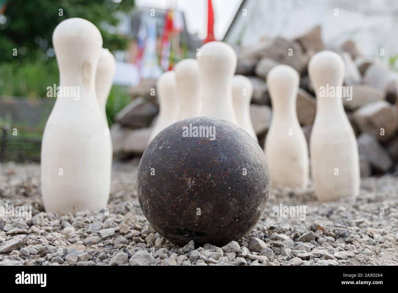 Ancient metal ball on the background of standing white pins. Stock Photo