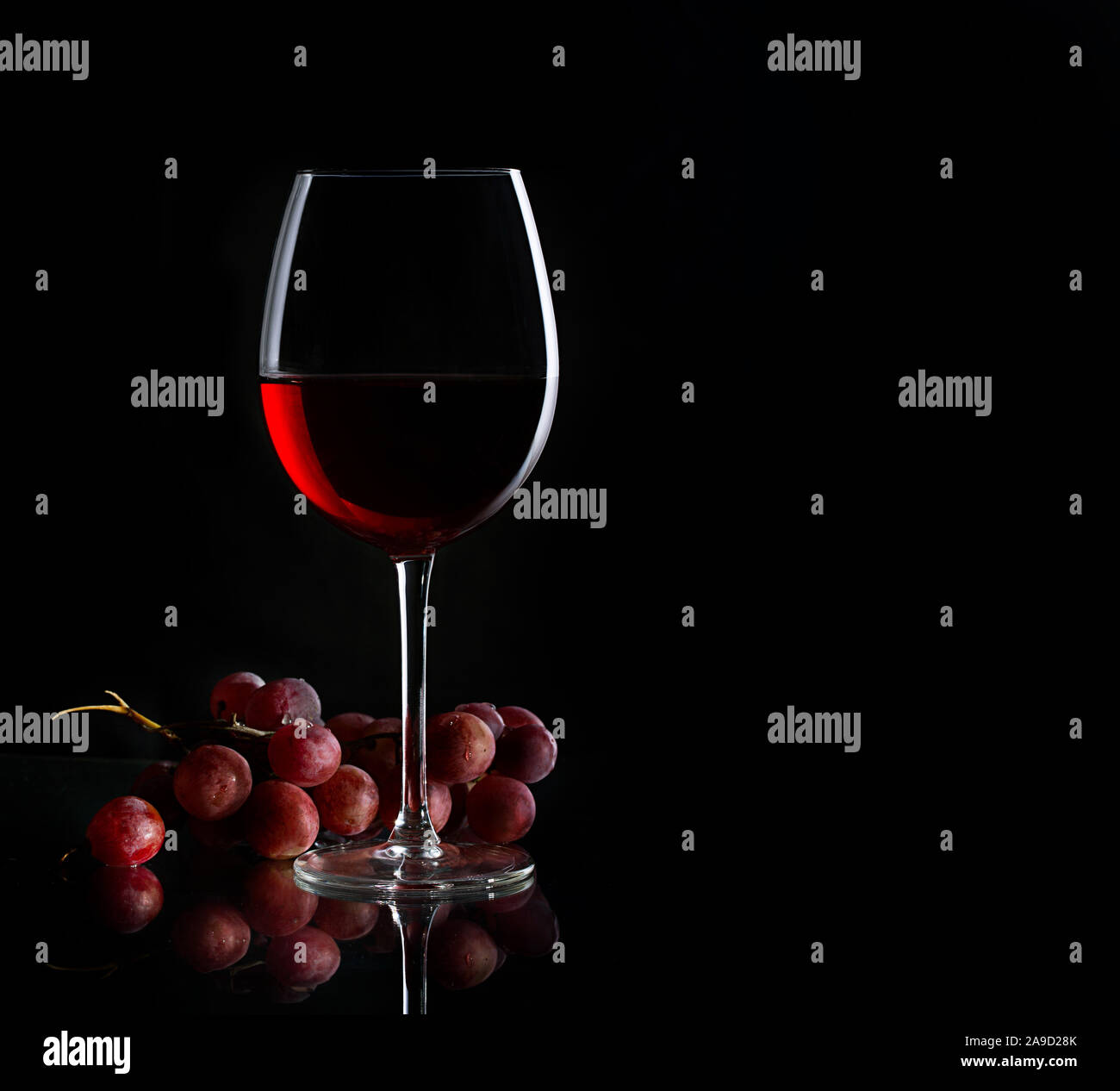 Glass of red wine and bunch of grapes on the dark background Stock ...