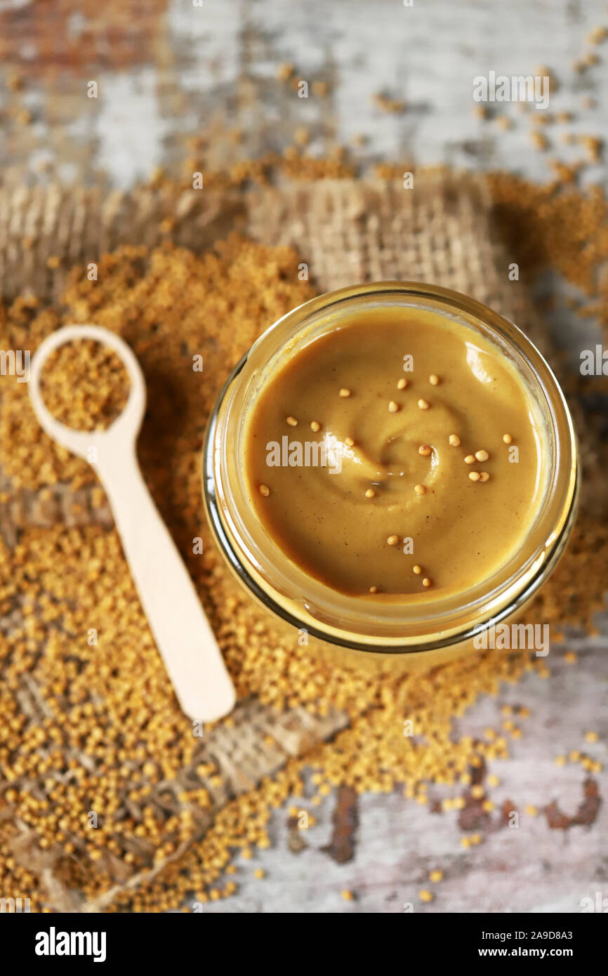 Natural mustard in a jar. Grains of mustard. Homemade mustard. Organic mustard. Selective focus. Macro. Stock Photo