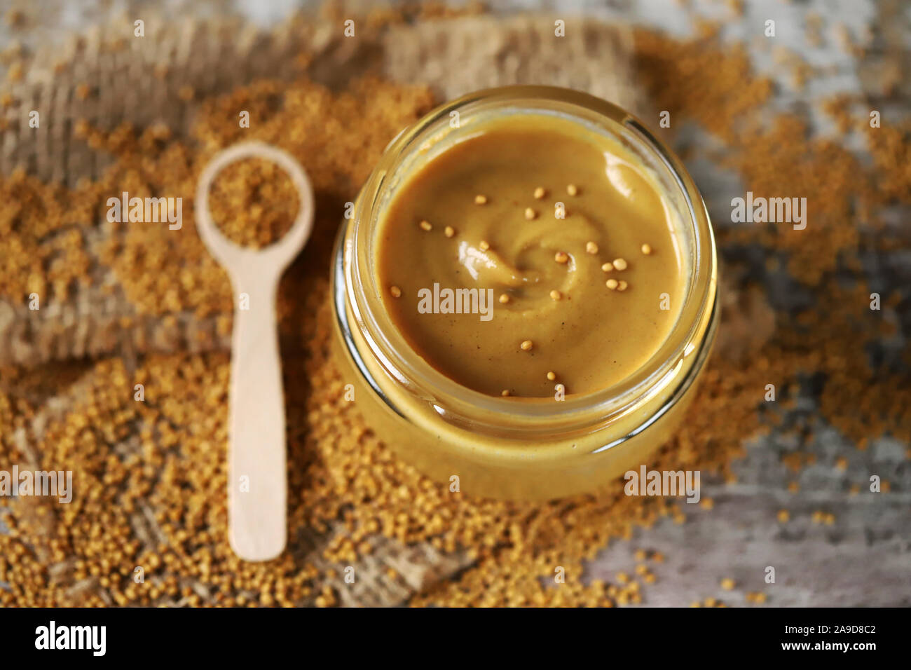 Natural mustard in a jar. Grains of mustard. Homemade mustard. Organic mustard. Selective focus. Macro. Stock Photo