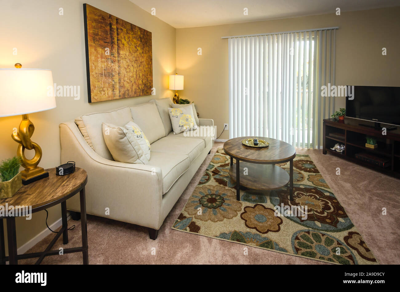 An apartment living room features a sliding glass door leading to the balcony at Autumn Woods apartment homes in Mobile, Alabama. Stock Photo