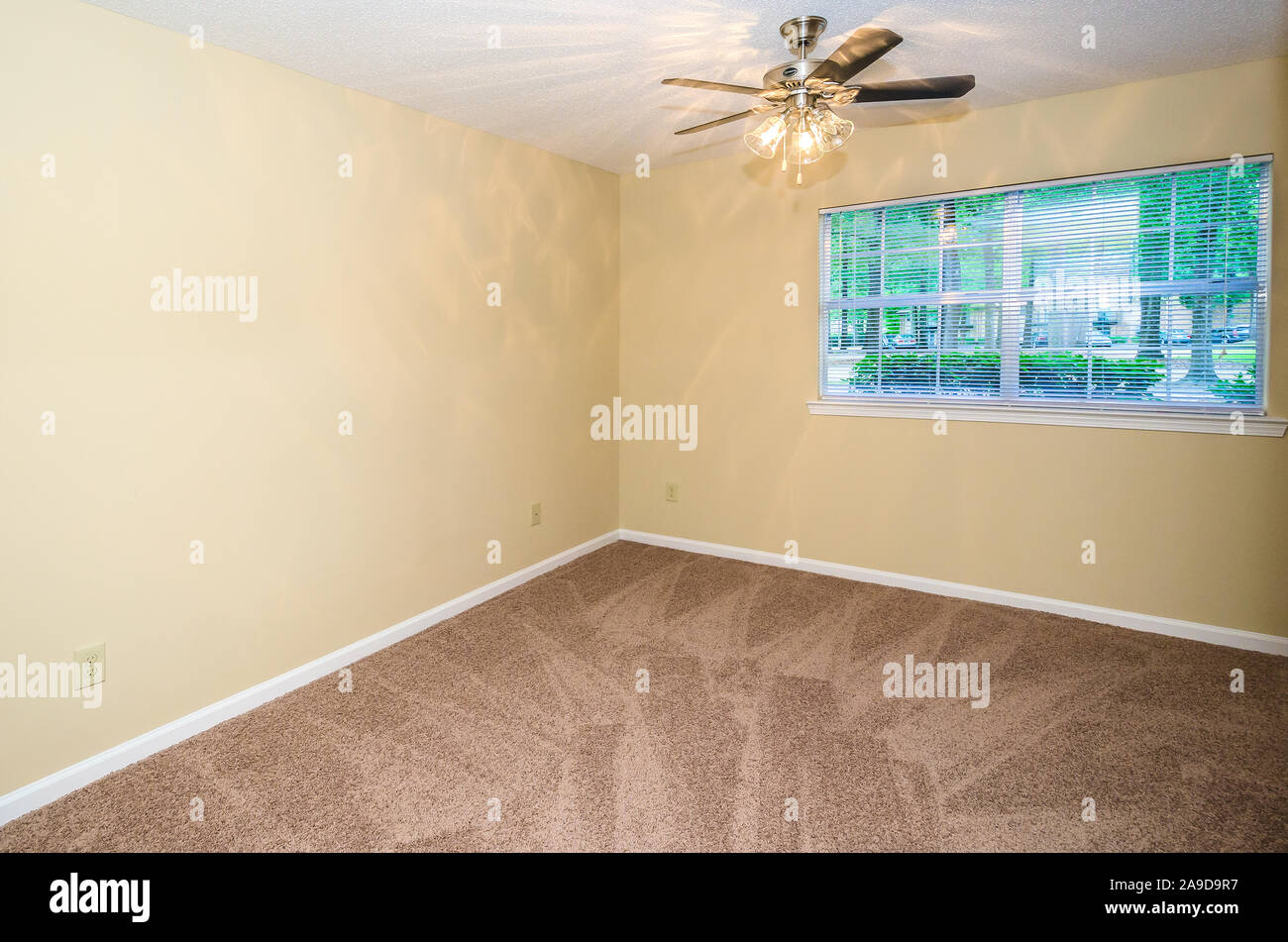An unfurnished, carpeted bedroom is pictured at Autumn Woods apartment homes in Mobile, Alabama. Stock Photo
