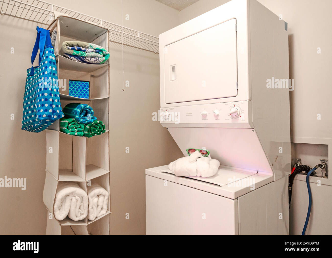 The laundry room features a stackable washer and dryer at Autumn Woods Apartments on Foreman Road in Mobile, Alabama. Stock Photo