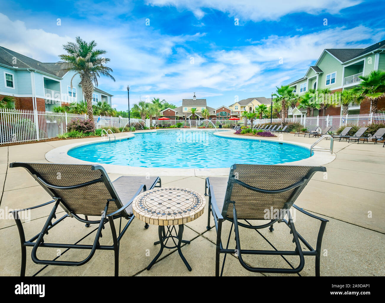 Lounge chairs overlook the swimming pool at Cypress Cove Apartment Homes in Mobile, Alabama. The apartment complex is owned and operated by Sealy. Stock Photo