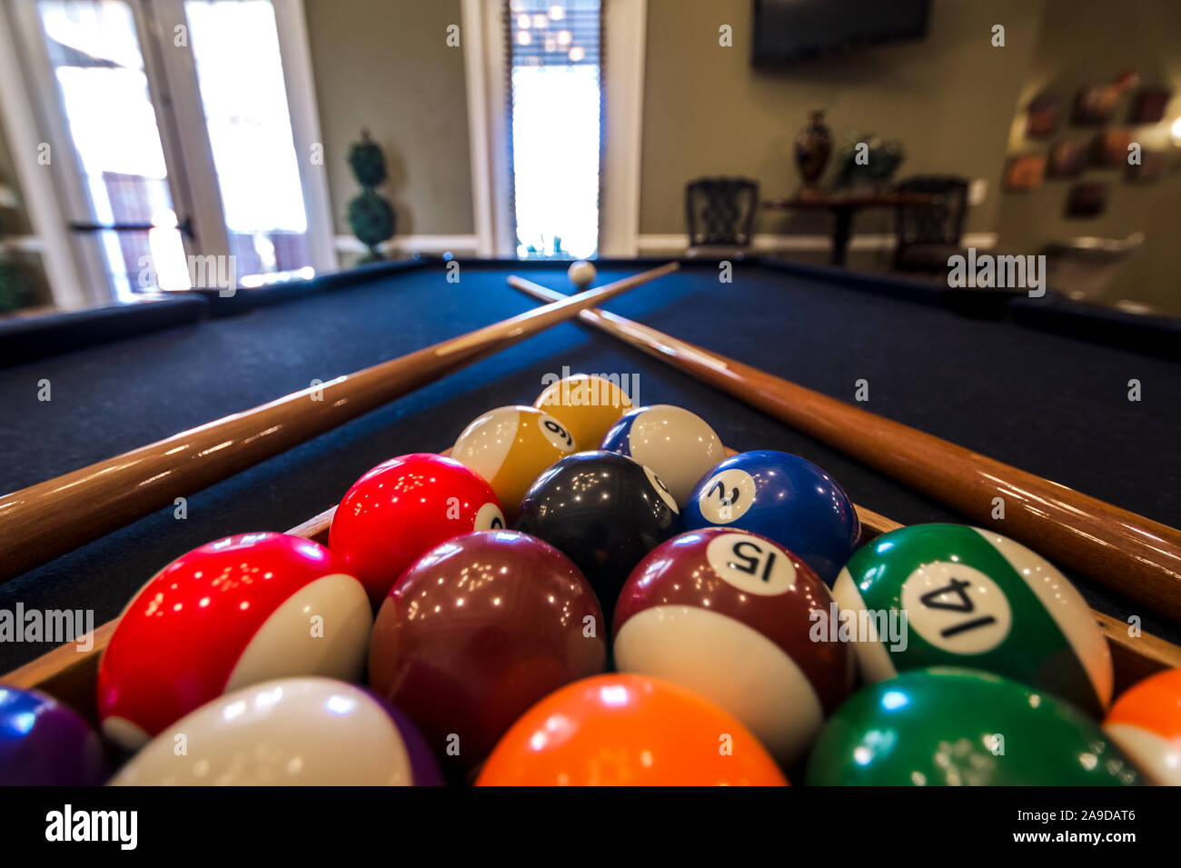 Billiard balls are racked on a pool table alongside two pool cues in the clubhouse at Cypress Cove Apartment Homes in Mobile, Alabama. Stock Photo