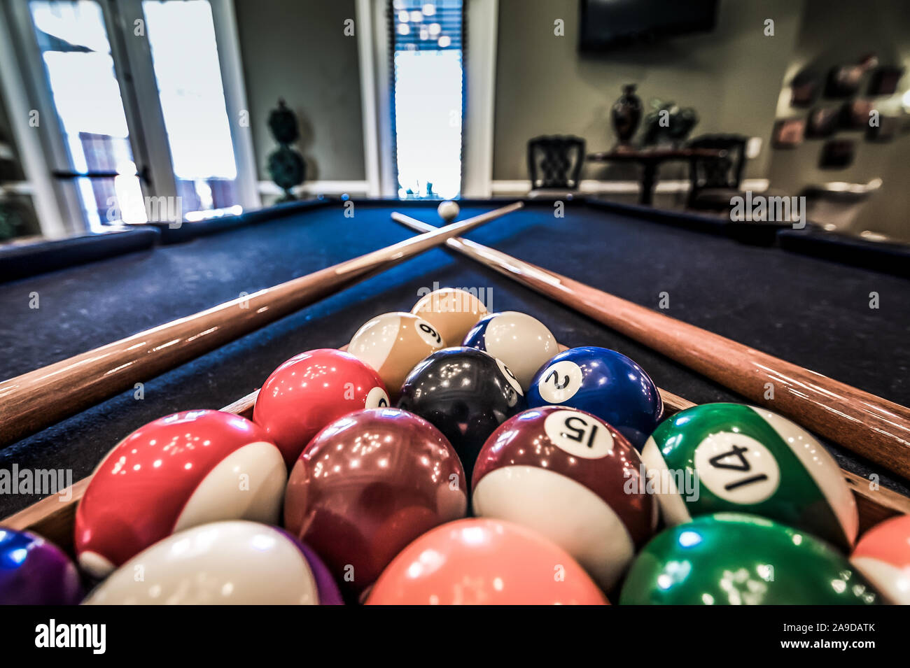Billiard balls are racked on a pool table alongside two pool cues in the clubhouse at Cypress Cove Apartment Homes in Mobile, Alabama. Stock Photo