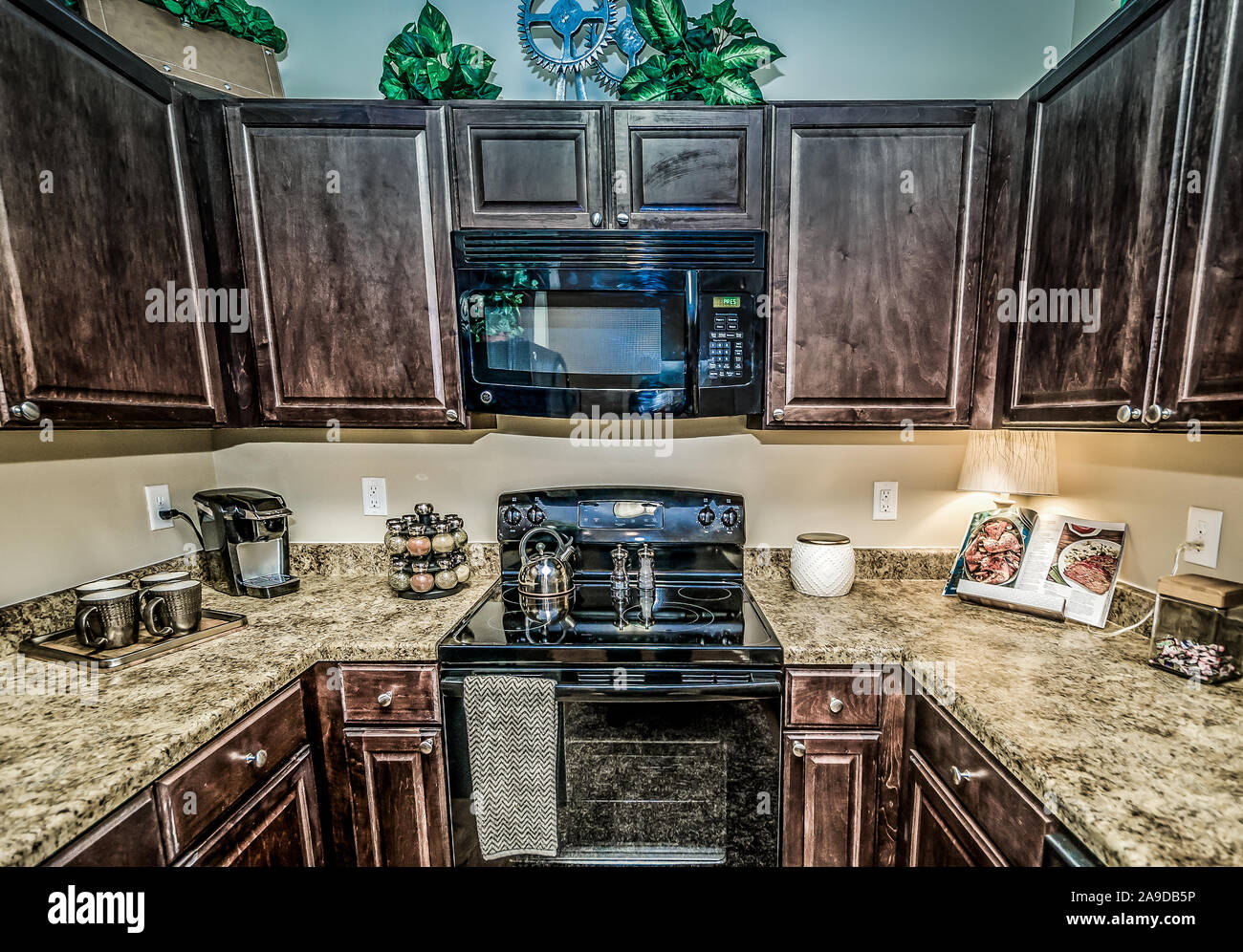 A Kitchen Features Granite Countertops Wooden Cabinets A Glass