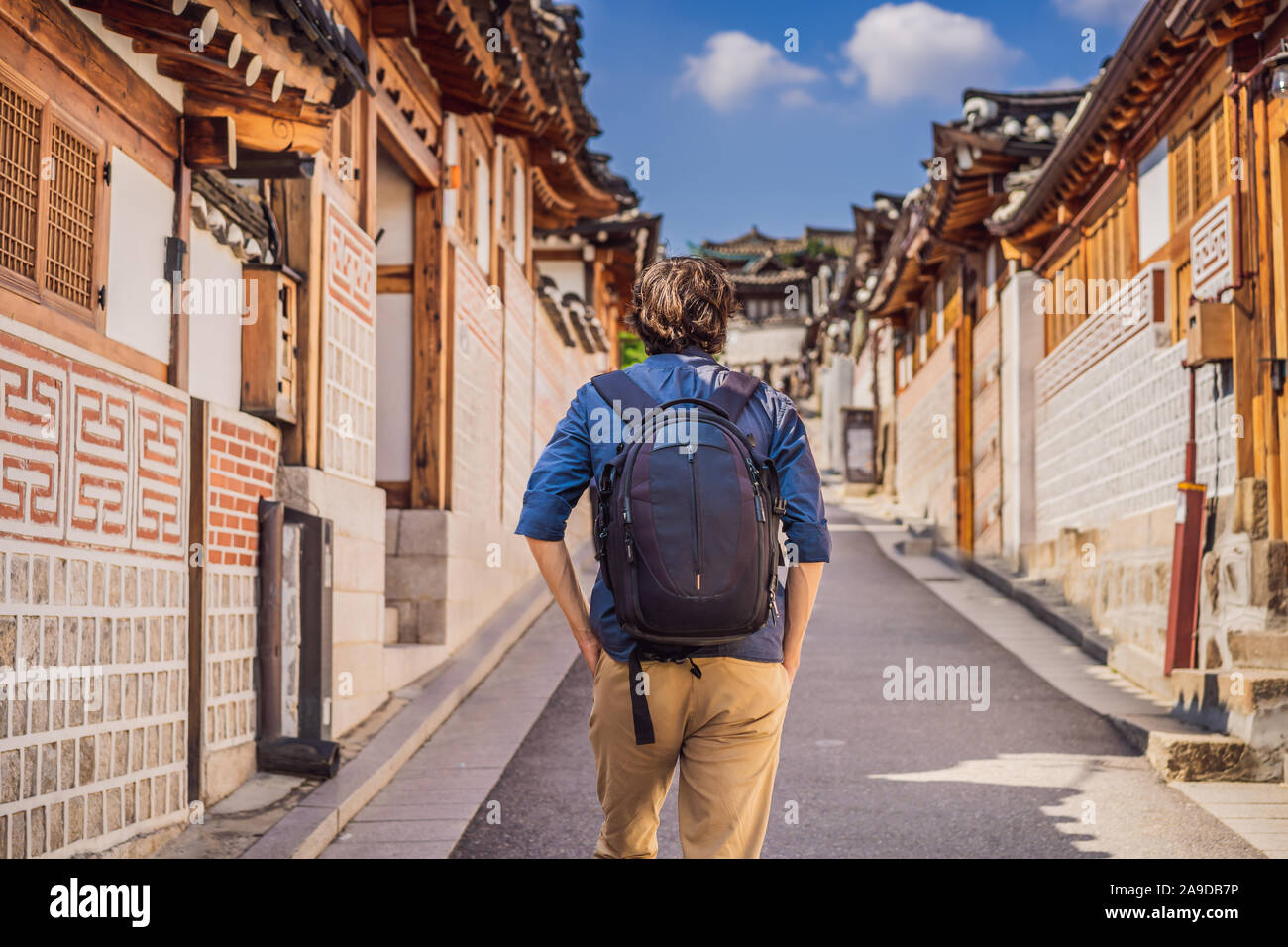 Young man tourist in Bukchon Hanok Village is one of the famous place for Korean traditional houses have been preserved. Travel to Korea Concept Stock Photo