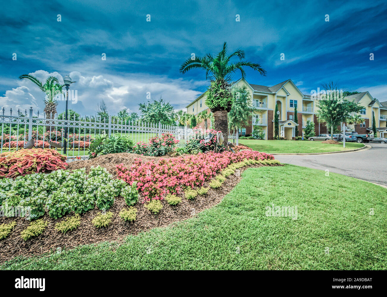 A flowerbed beautifies the entrance at Cypress Cove Apartment Homes in