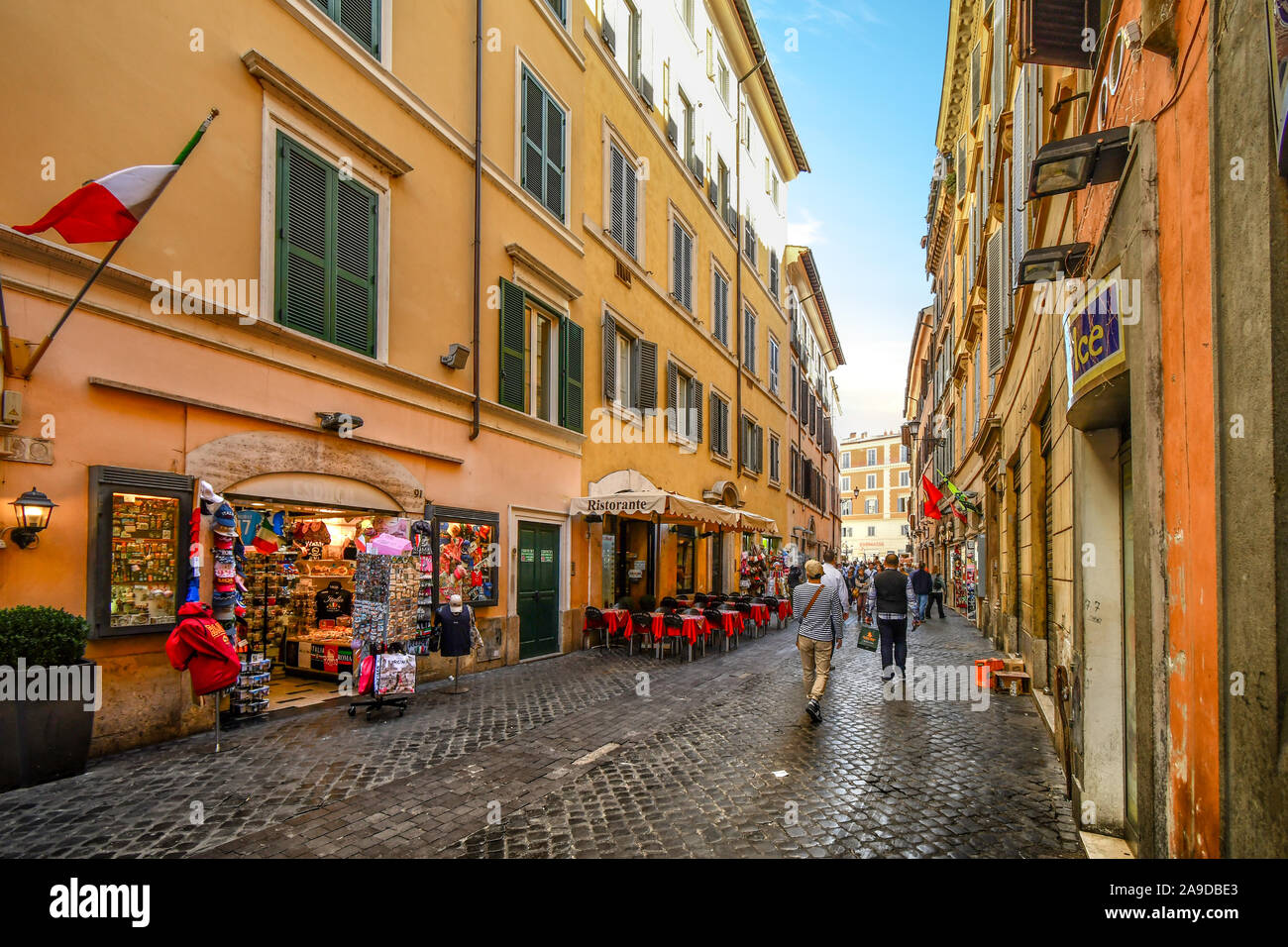 A cobblestone side street with sidewalk cafes and souvenir shops in the historic center of Rome, Italy Stock Photo